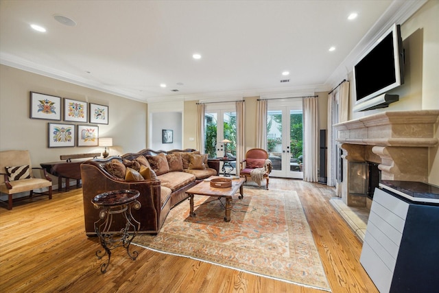 5710 Logan Ln, Houston, TX 77007 - living area featuring ornamental molding, light wood finished floors, a fireplace with raised hearth, recessed lighting, and french doors