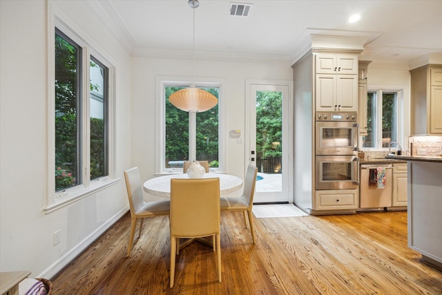 5710 Logan Ln, Houston, TX 77007 - dining space with light wood-style floors, crown molding, and baseboards