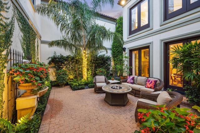 5710 Logan Ln, Houston, TX 77007 - patio terrace at dusk with a patio, an outdoor living space with a fire pit, and french doors