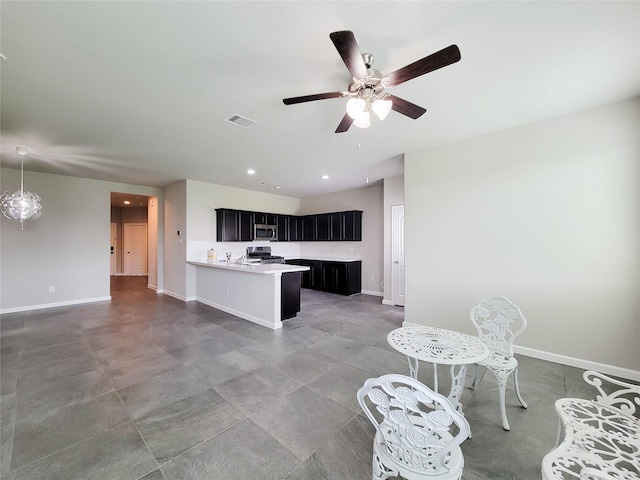 5426 Redwood Summit Ln, Katy, TX 77449 - kitchen featuring stainless steel microwave, dark cabinets, stove, light countertops, and a ceiling fan