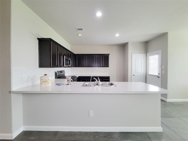 5426 Redwood Summit Ln, Katy, TX 77449 - kitchen with stainless steel appliances, a peninsula, light countertops, recessed lighting, and tasteful backsplash
