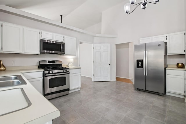 5551 Fawn Trail Ln, Humble, TX 77346 - kitchen featuring appliances with stainless steel finishes, high vaulted ceiling, light countertops, white cabinetry, and a chandelier