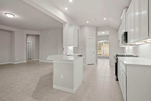 207 Little Dog Dr, Montgomery, TX 77356 - kitchen with stainless steel appliances, a sink, light tile patterned floors, light countertops, and white cabinetry