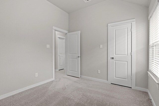 207 Little Dog Dr, Montgomery, TX 77356 - unfurnished bedroom featuring light carpet, vaulted ceiling, multiple windows, and baseboards