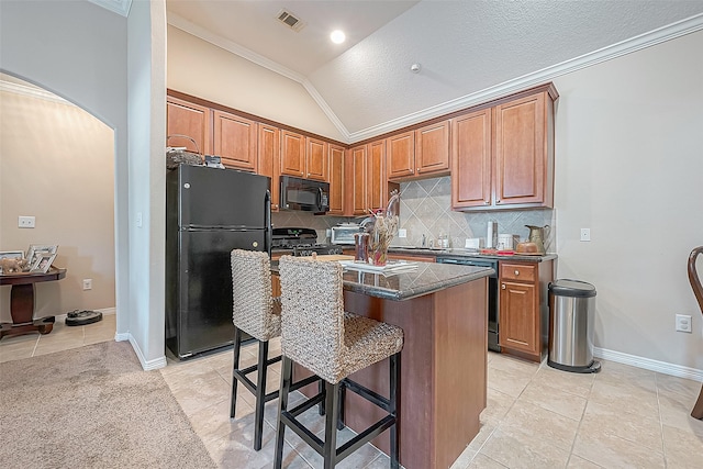 20904 Sunrise Pine View Ln, Katy, TX 77450 - kitchen with black appliances, lofted ceiling, light tile patterned floors, crown molding, and dark countertops