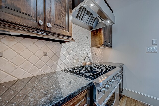 311 Calle Sevilla Pl, Houston, TX 77007 - kitchen featuring wall chimney range hood, stainless steel range, dark brown cabinetry, baseboards, and backsplash