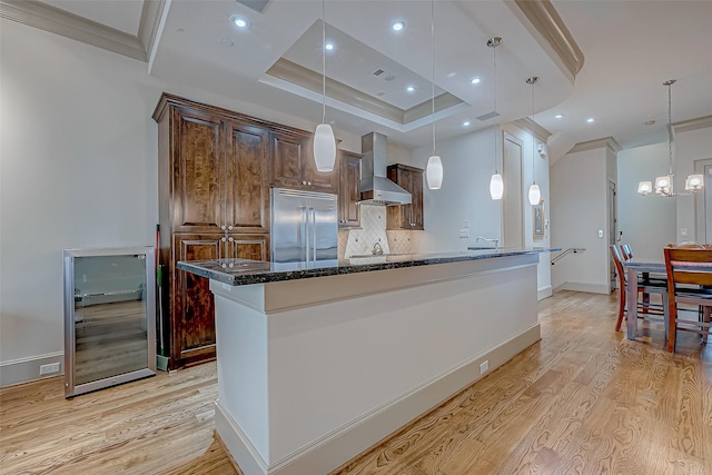311 Calle Sevilla Pl, Houston, TX 77007 - kitchen featuring wall chimney range hood, built in refrigerator, light wood finished floors, a chandelier, and decorative backsplash