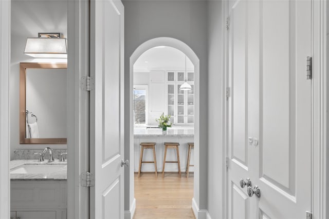1705 Michigan St, Houston, TX 77006 - hall featuring a sink, light wood-style flooring, and arched walkways