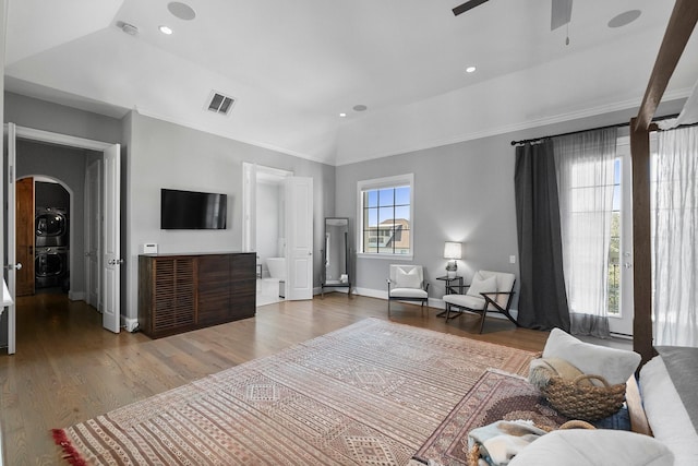 1705 Michigan St, Houston, TX 77006 - bedroom with stacked washer and clothes dryer, arched walkways, wood finished floors, baseboards, and vaulted ceiling