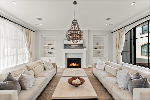 1705 Michigan St, Houston, TX 77006 - living room featuring built in shelves, a glass covered fireplace, ornamental molding, recessed lighting, and wood finished floors
