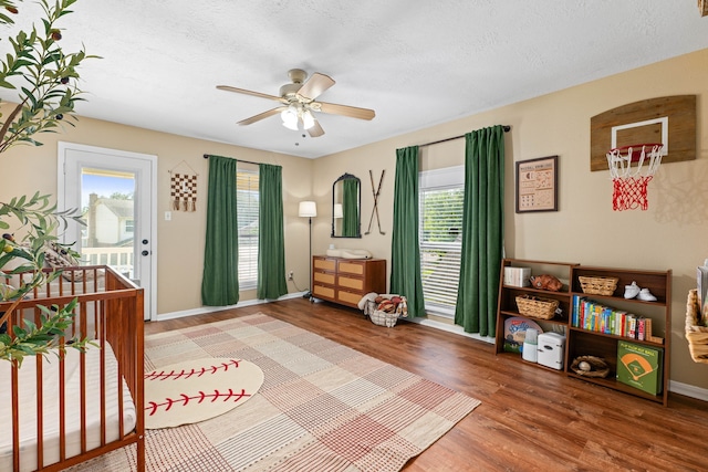 3911 Rushcroft Dr, Houston, TX 77082 - bedroom with wood finished floors, access to outside, multiple windows, a textured ceiling, and baseboards