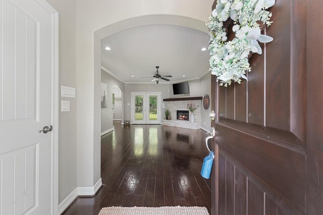 532 County Road 632, Dayton, TX 77535 - foyer featuring arched walkways, ornamental molding, a ceiling fan, a lit fireplace, and hardwood / wood-style flooring