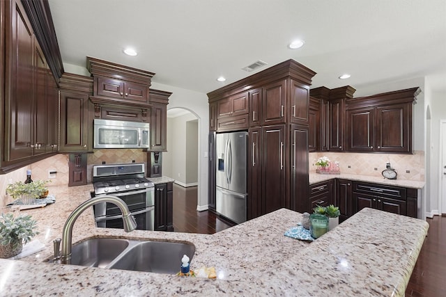 532 County Road 632, Dayton, TX 77535 - kitchen featuring appliances with stainless steel finishes, a sink, dark wood-type flooring, dark brown cabinetry, and tasteful backsplash