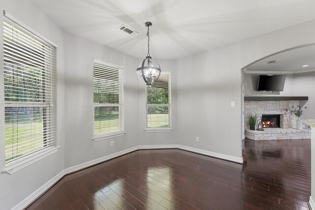 532 County Road 632, Dayton, TX 77535 - unfurnished dining area with baseboards, a stone fireplace, wood-type flooring, and a chandelier
