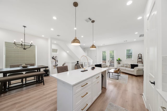 1503 Evelyn St, Houston, TX 77009 - kitchen featuring a kitchen island, light countertops, light wood-type flooring, white cabinets, and recessed lighting