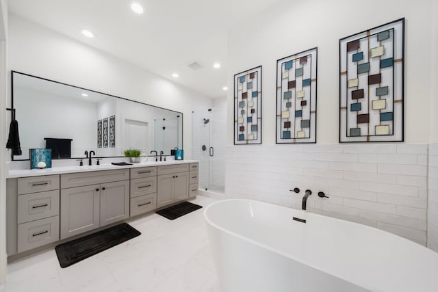 1503 Evelyn St, Houston, TX 77009 - bathroom featuring double vanity, a stall shower, a freestanding tub, recessed lighting, and marble finish floors