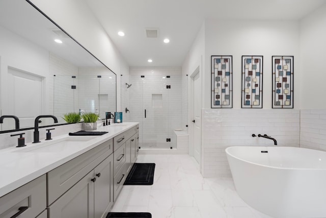 1503 Evelyn St, Houston, TX 77009 - bathroom featuring double vanity, a shower stall, recessed lighting, a freestanding tub, and marble finish flooring