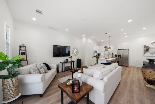 1503 Evelyn St, Houston, TX 77009 - living room featuring light wood finished floors, recessed lighting, and baseboards