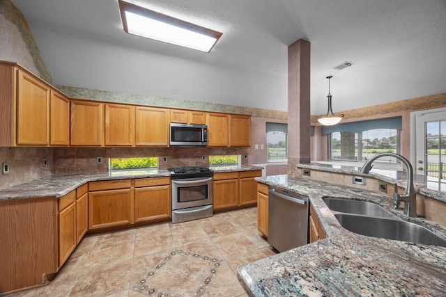 2723 Shelby Dr, Pearland, TX 77584 - kitchen featuring appliances with stainless steel finishes, a sink, tasteful backsplash, light stone countertops, and vaulted ceiling