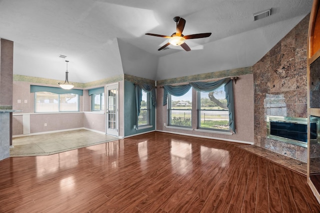 2723 Shelby Dr, Pearland, TX 77584 - unfurnished living room with lofted ceiling, a ceiling fan, a tiled fireplace, and wood finished floors