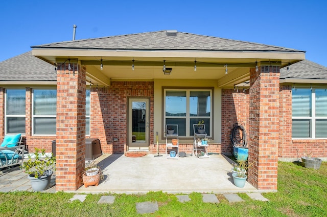 2109 Sunset Terrace Ln, Houston, TX 77089 - rear view of property featuring a shingled roof, brick siding, and a patio area