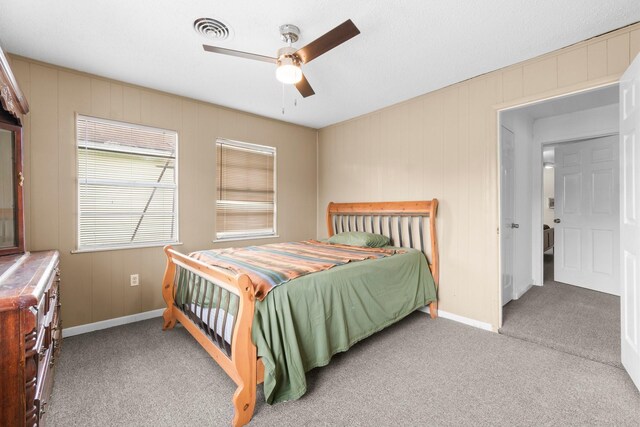 168 Bay Haven Blvd, Livingston, TX 77351 - carpeted bedroom featuring baseboards, a ceiling fan, and wood walls
