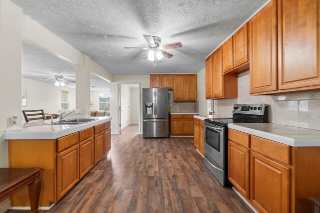 168 Bay Haven Blvd, Livingston, TX 77351 - kitchen with appliances with stainless steel finishes, ceiling fan, a sink, dark wood-type flooring, and decorative backsplash