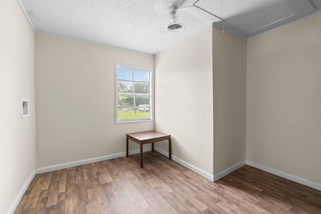 168 Bay Haven Blvd, Livingston, TX 77351 - spare room featuring attic access, wood finished floors, crown molding, baseboards, and a textured ceiling