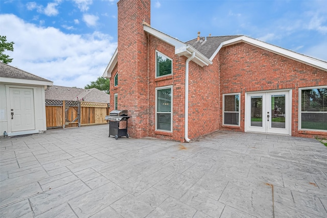 3406 Mesquite Dr, Sugar Land, TX 77479 - back of property with a patio area, french doors, brick siding, a chimney, and a shingled roof