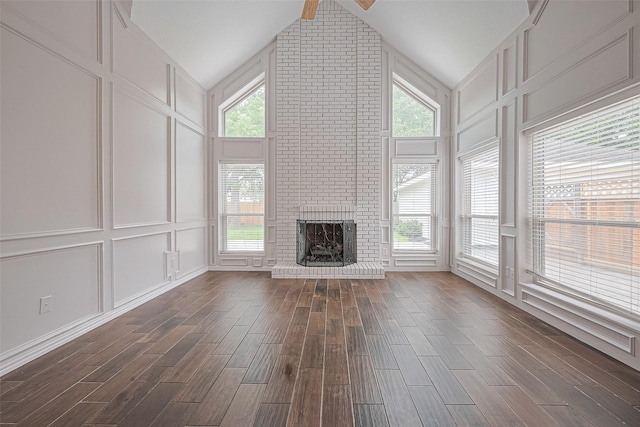 3406 Mesquite Dr, Sugar Land, TX 77479 - unfurnished living room with a decorative wall, dark wood finished floors, lofted ceiling, a brick fireplace, and plenty of natural light