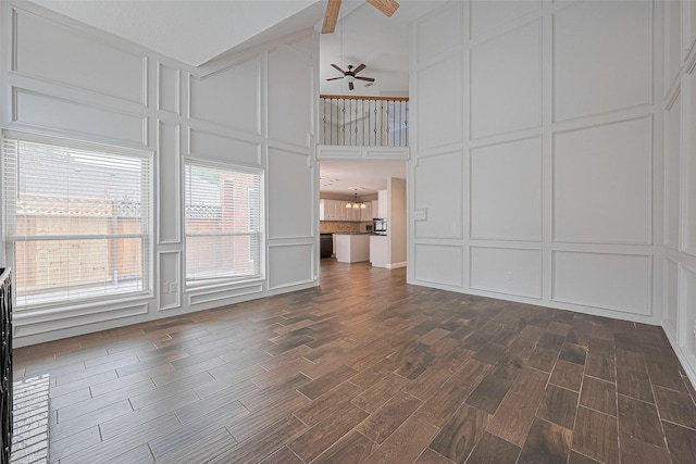 3406 Mesquite Dr, Sugar Land, TX 77479 - unfurnished living room featuring a decorative wall, a ceiling fan, dark wood-style floors, and high vaulted ceiling