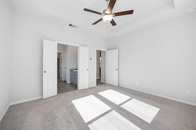 25494 Blossom Ct, Montgomery, TX 77316 - unfurnished bedroom with light carpet, a raised ceiling, baseboards, and connected bathroom