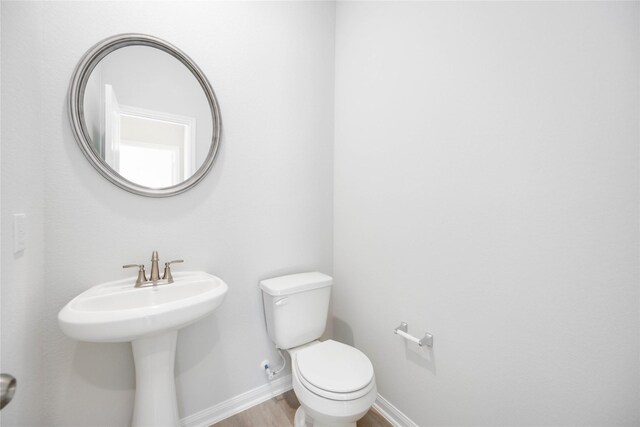 25494 Blossom Ct, Montgomery, TX 77316 - bathroom with wood finished floors, baseboards, and toilet