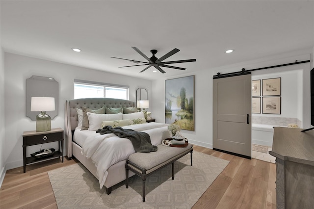 10090 Valley Dr S, Willis, TX 77318 - bedroom featuring a barn door, light wood-style flooring, baseboards, recessed lighting, and a ceiling fan