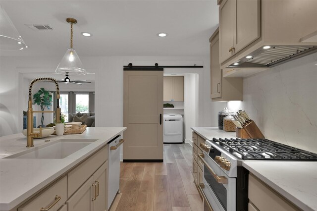 10090 Valley Dr S, Willis, TX 77318 - kitchen featuring white appliances, a sink, washer / dryer, a barn door, and light wood-type flooring