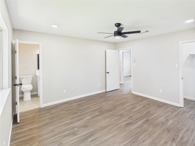 3219 Ricewood Dr, Porter, TX 77365 - unfurnished bedroom with light wood finished floors, a walk in closet, baseboards, ensuite bath, and recessed lighting