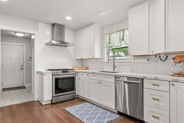 10618 Cranbrook Rd, Houston, TX 77042 - kitchen with wall chimney exhaust hood, appliances with stainless steel finishes, a sink, tasteful backsplash, and white cabinets