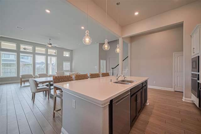 1718 Pepper Grove Ln, Katy, TX 77494 - kitchen featuring appliances with stainless steel finishes, a sink, light wood-style flooring, a breakfast bar, and light countertops
