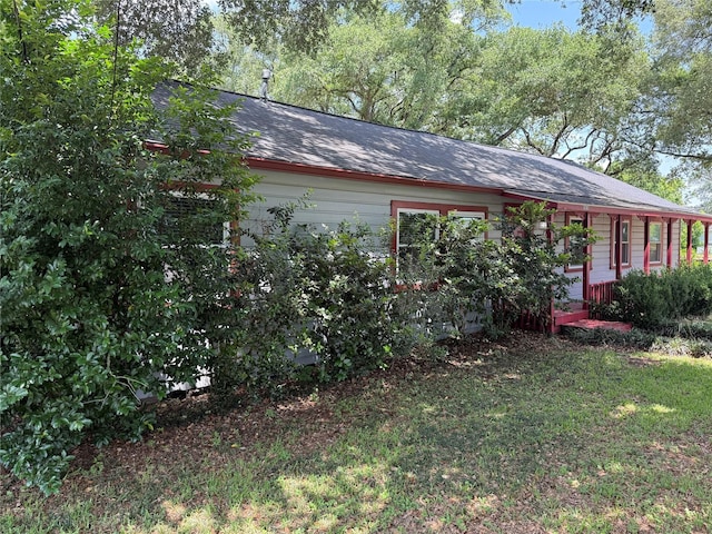 1707 Key St, Waller, TX 77484 - view of property exterior with covered porch, an attached garage, roof with shingles, and a yard