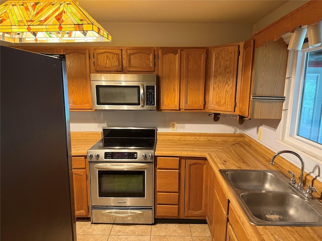1707 Key St, Waller, TX 77484 - kitchen featuring stainless steel appliances, a sink, light countertops, and brown cabinets