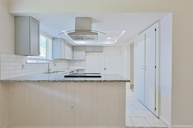 9910 Kent Towne Ln, Sugar Land, TX 77498 - kitchen with a sink, a peninsula, light stone countertops, decorative backsplash, and recessed lighting