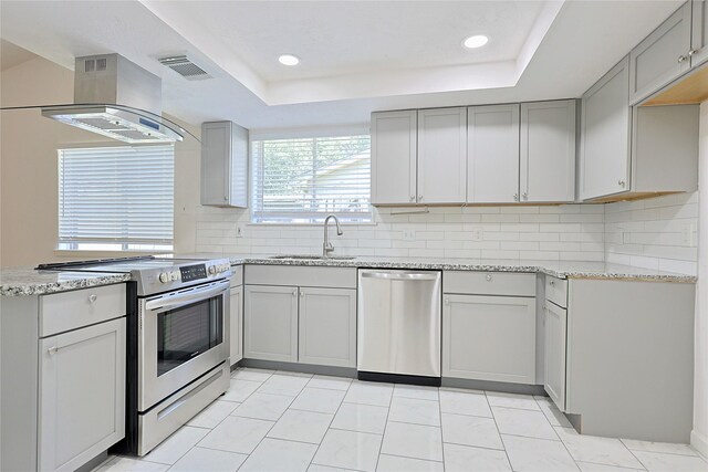 9910 Kent Towne Ln, Sugar Land, TX 77498 - kitchen featuring stainless steel appliances, a sink, gray cabinets, island range hood, and backsplash