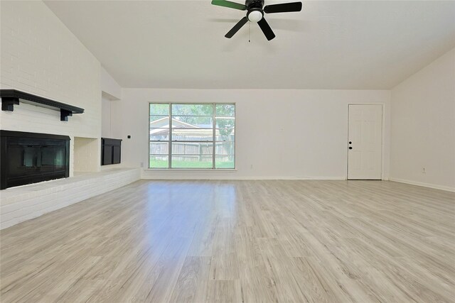 9910 Kent Towne Ln, Sugar Land, TX 77498 - unfurnished living room featuring lofted ceiling, light wood-style flooring, ceiling fan, a fireplace, and baseboards