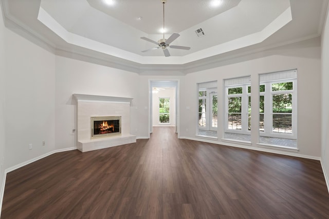 110 Canterbury Green Dr, Conroe, TX 77356 - unfurnished living room with a raised ceiling, a ceiling fan, plenty of natural light, and dark wood-style flooring