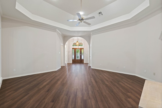 110 Canterbury Green Dr, Conroe, TX 77356 - unfurnished room with a raised ceiling, dark wood-style flooring, arched walkways, and a ceiling fan
