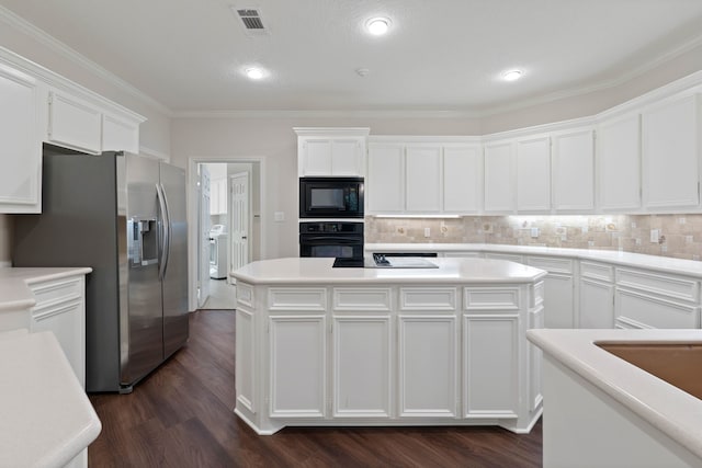 110 Canterbury Green Dr, Conroe, TX 77356 - kitchen featuring black appliances, washer / dryer, white cabinetry, a kitchen island, and tasteful backsplash