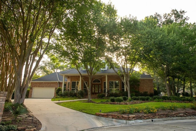 110 Canterbury Green Dr, Conroe, TX 77356 - view of front facade with brick siding, driveway, a garage, and a front lawn