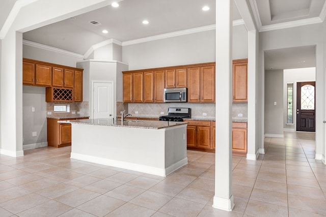 18738 Fox Kestrel Trl, Cypress, TX 77429 - kitchen featuring stainless steel microwave, gas stove, brown cabinets, light tile patterned floors, and ornamental molding