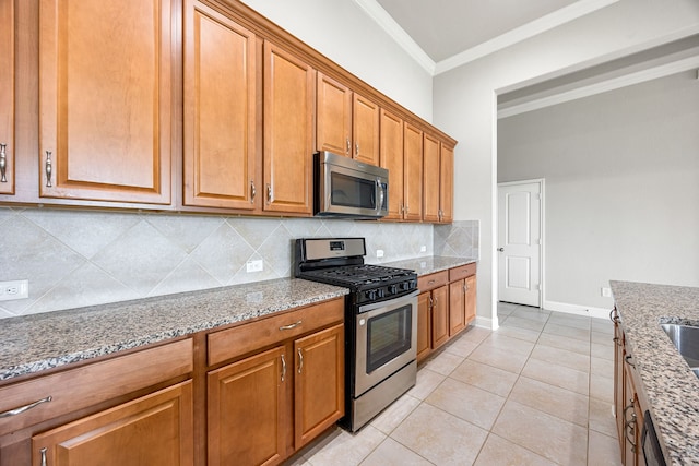 18738 Fox Kestrel Trl, Cypress, TX 77429 - kitchen featuring stainless steel appliances, light stone countertops, backsplash, brown cabinetry, and ornamental molding