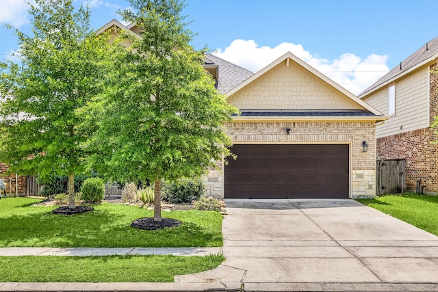 18738 Fox Kestrel Trl, Cypress, TX 77429 - view of front of home with a front yard, driveway, an attached garage, stone siding, and a shingled roof
